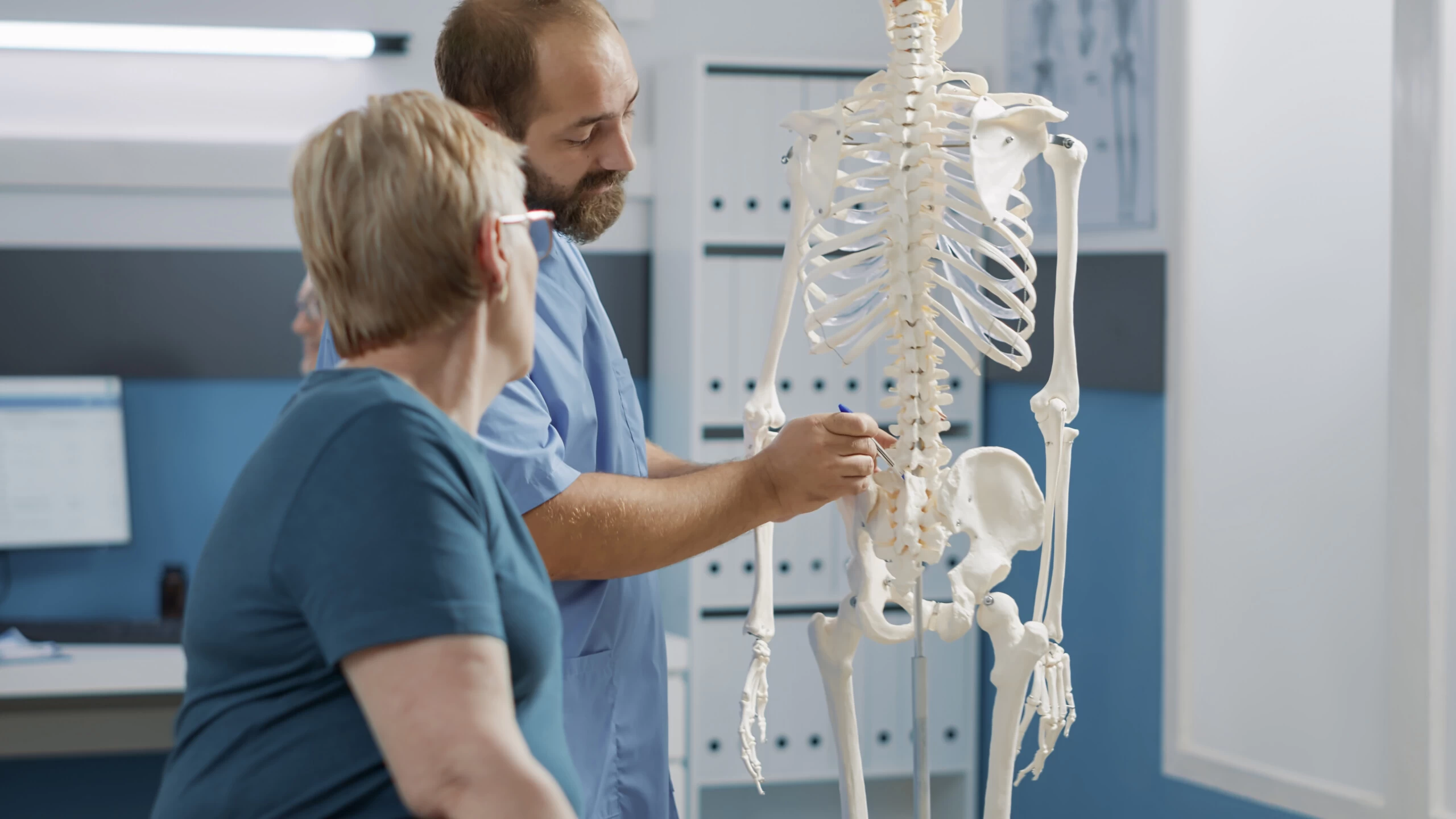 male doctor pointing human skeleton show spinal cord explain mechanical disorders rehabilitation cabinet specialist explaining back bones system physical therapy scaled male doctor pointing human skeleton show spinal cord explain mechanical disorders rehabilitation cabinet specialist explaining back bones system physical therapy scaled